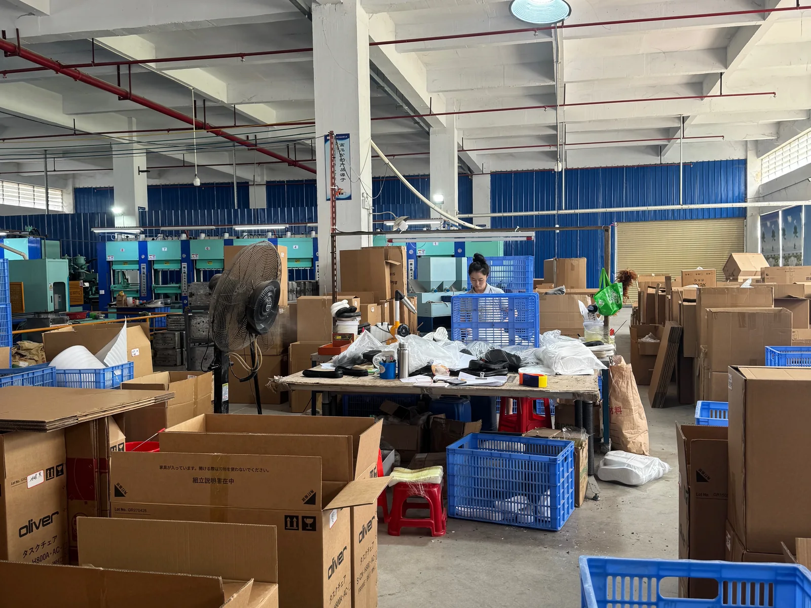 Packing area with finished EVA soles, cartons and storage crates.